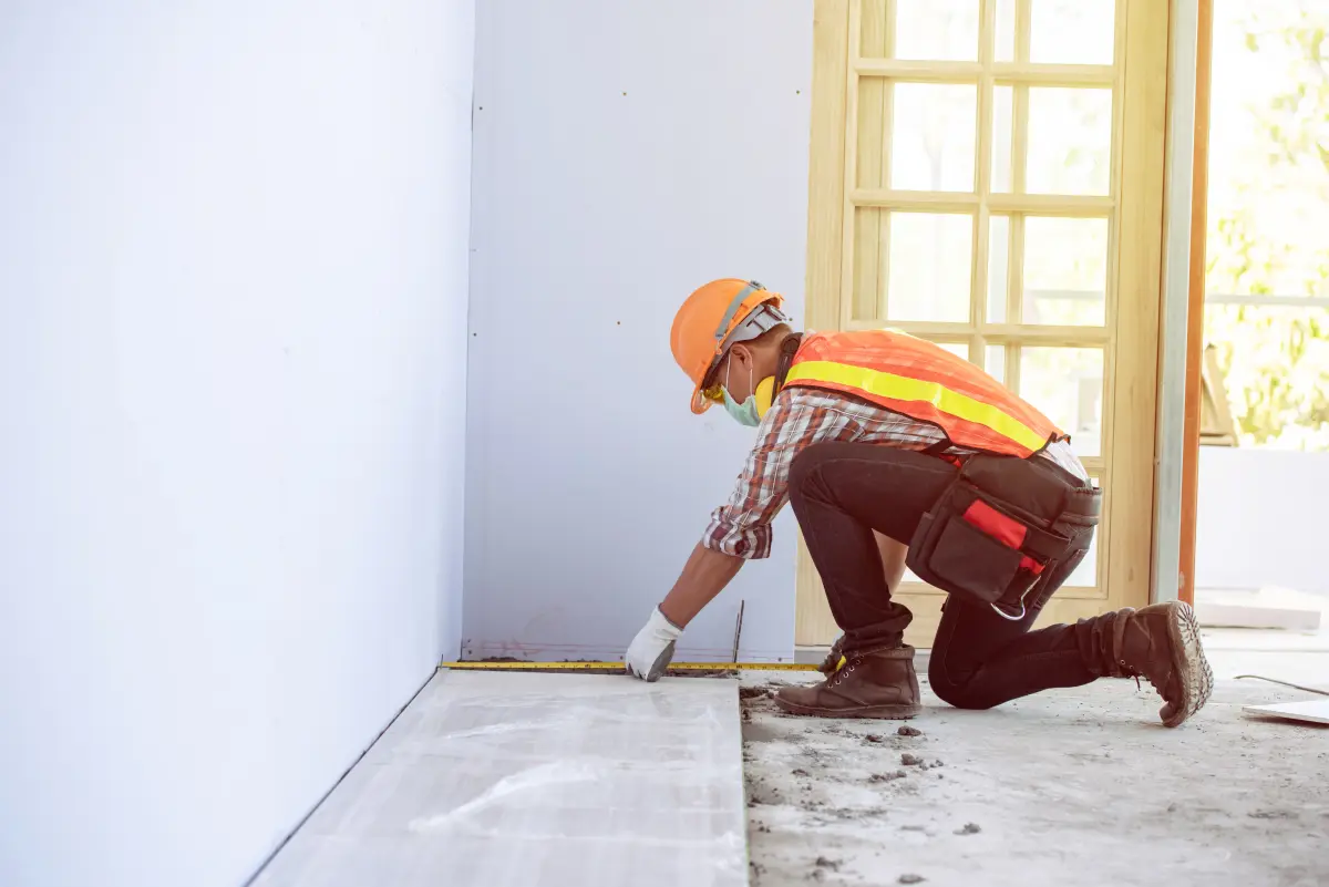 Worker measuring flooring during an interior buildout
