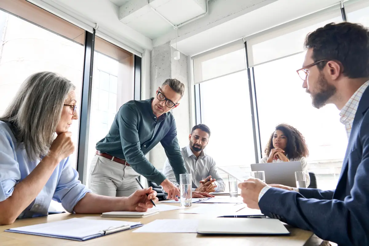 Business team reviewing contract documents around a table