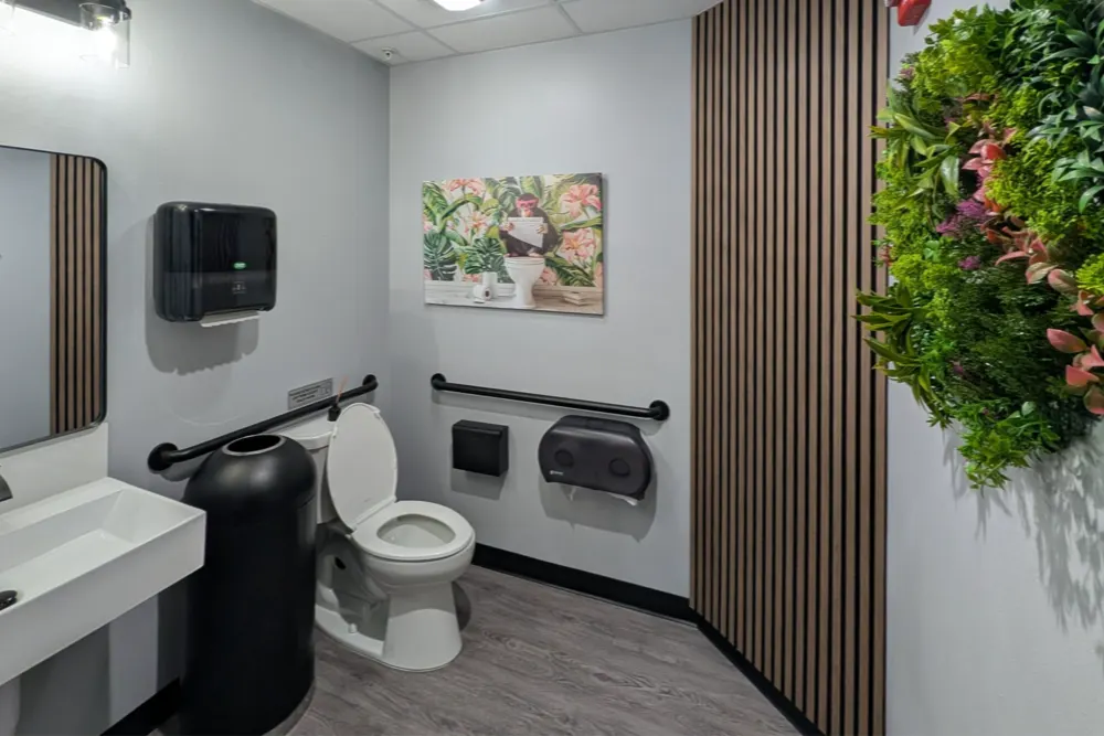ADA restroom with black fixtures and wood-slat accent wall