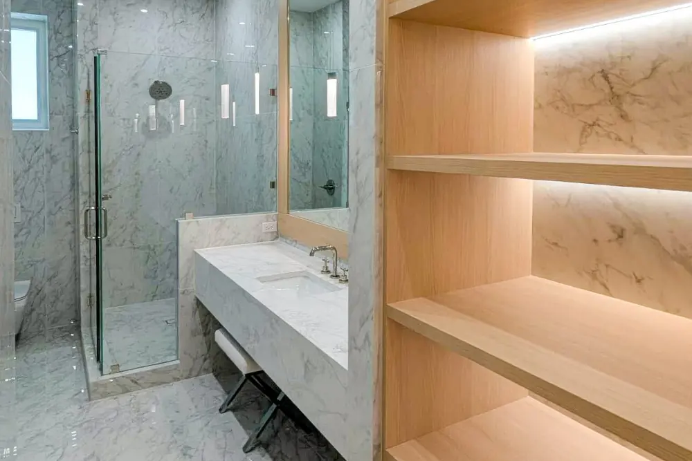 Marble bathroom with built-in oak shelving