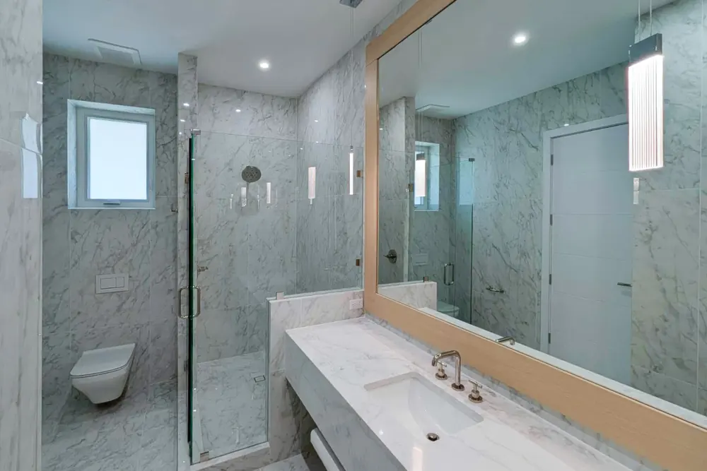 Marble bathroom with curbless glass shower in downtown Sarasota