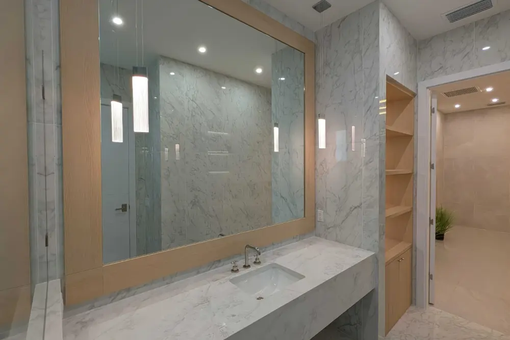 Stone vanity with pendant lights in a marble bathroom