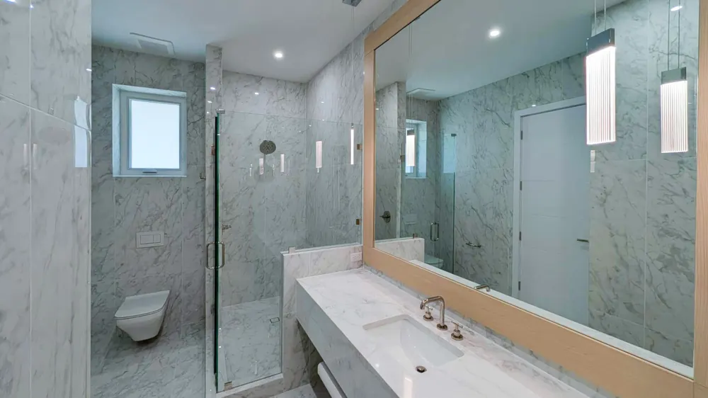 Marble bathroom with curbless glass shower at a downtown Sarasota spa