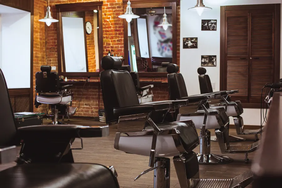 Salon interior with styling stations, mirrors and leather chairs